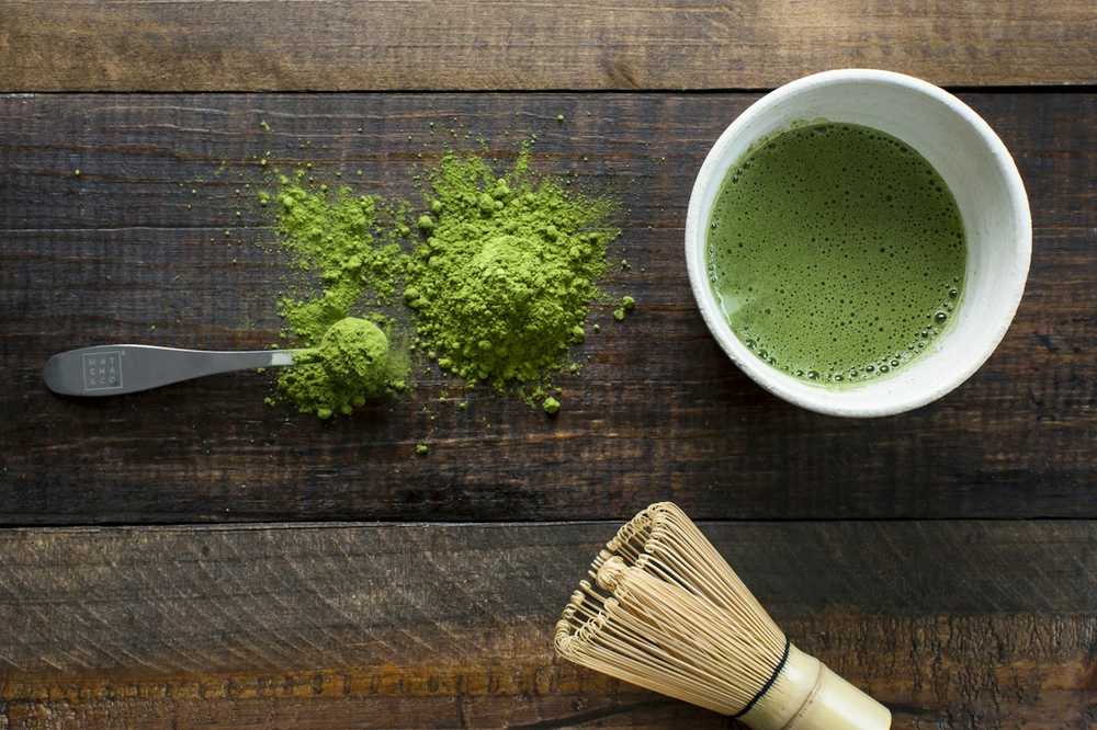 Bột trà và chổi tre trên bàn gỗ (ảnh mẫu)